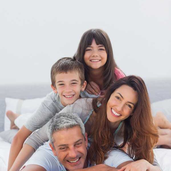 Parents-and-their-children-lying-on-each-other's-back-on-a-beach-sand-in-simple-ways-to-discover-your-child's-love-language-for-better-parenting