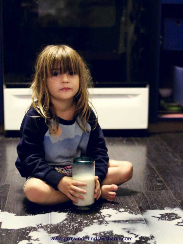 A-child-holding-cup-of-drink-and-spilled-drink-in-the-floor