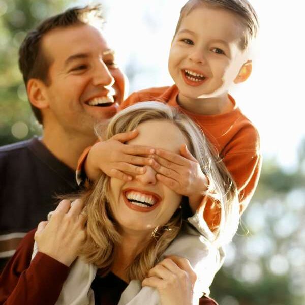 father-in-black-with-mum-in-brown-and-their-child-inorange-colour-covering-the-mother's-eye-in-10-common-parenting-mistake-to-avoid-in-your-child's-early-years