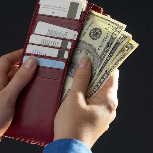 a-hand-bringing-out-money-from-wallet-in-6-money-habits-your-child-is-learning-from-you-without-you-realizing-it