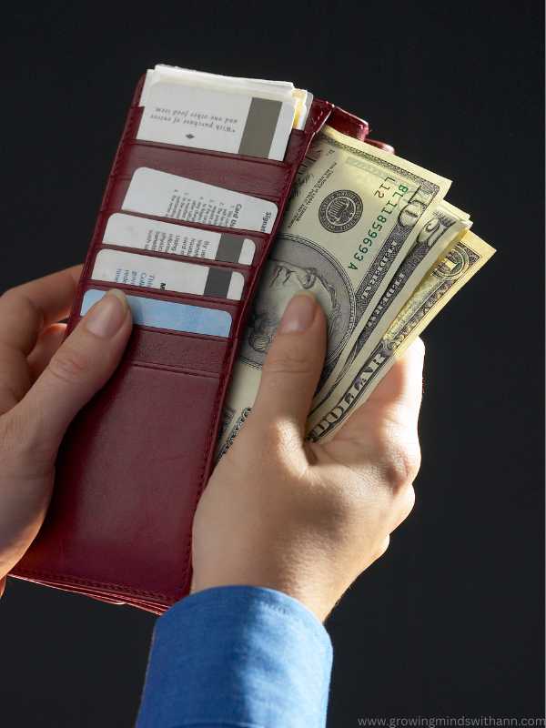 a-hand-bringing-out-money-from-wallet-in-6-money-habits-your-child-is-learning-from-you-without-you-realizing-it