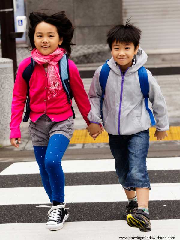 Girl-in-blue-trouser-and-red-polo-holding-hands-with-a-boy-in-white-top-and-bue-trouser-in-practical-ways-to-raise-confidennt-and-independent-kids