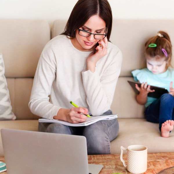 A-mom-working-with-computer-with-her-daughter-beside-her-in-how-to-slow-down-and-be-mindful-as-a-busy-mom