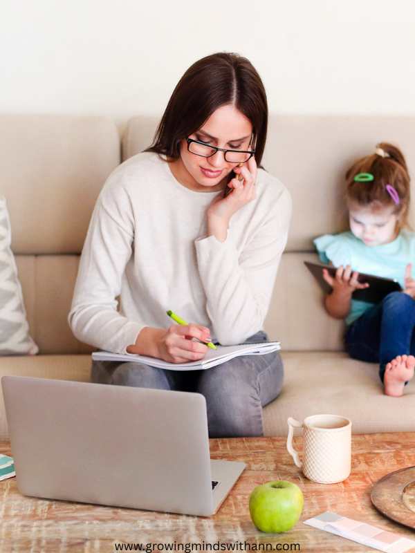 A-mom-working-with-computer-with-her-daughter-beside-her-in-how-to-slow-down-and-be-mindful-as-a-busy-mom
