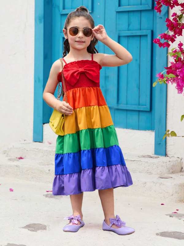 Girl-wearing-gown-made-with-red-orange-green-purple-yellow-blue-colors-with-sunglass-and-hand-bag.