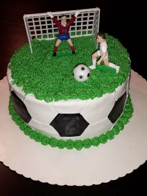 Cake-made-like-a-football-field-with-a-striker-playing-ball-and-a-goalkeeper-in-the-goal-post.