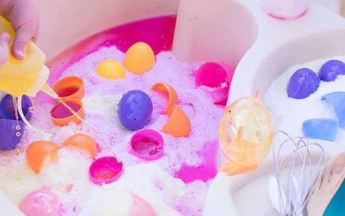 Plastic-eggs-of-different-colors-fizzing-in-a-bowl-of-water-in-fun-Easter-STEM-activities-for-kids.