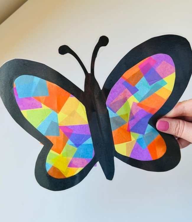 Sun-catcher-butterfly-made-with-different-colors-held-with-hand-while-facing-the-sun-in-fun-and-creative-spring-crafts-for-preschoolers.