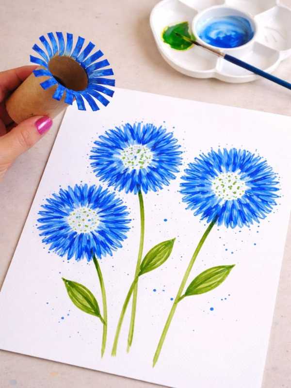 Hand-holding-toilet-roll-and-flowers-designed-with-the-toilet-roll-with-blue-painting-in-lovely-mother's-day-flower-crafts-for kids.