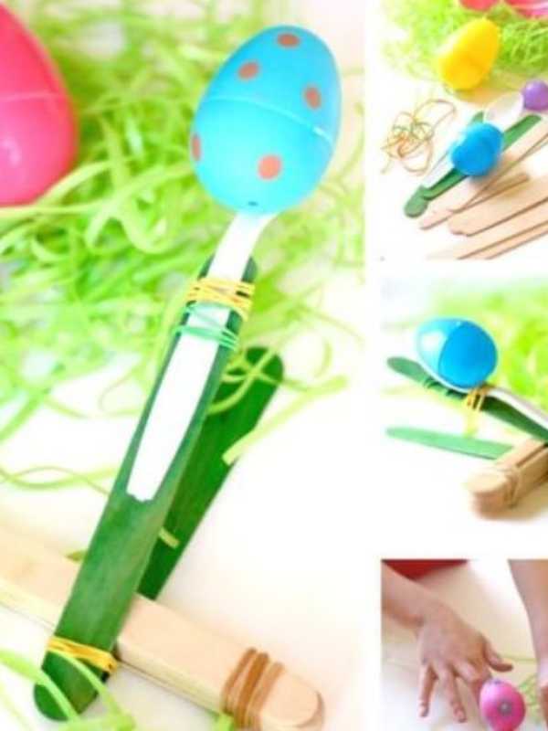 Catapult-made-from-popscile-stick-rubber-band-rubber-spoon-with-plastic-egg-on-the-spoon-ready-to-be-toasted-into-the-air.