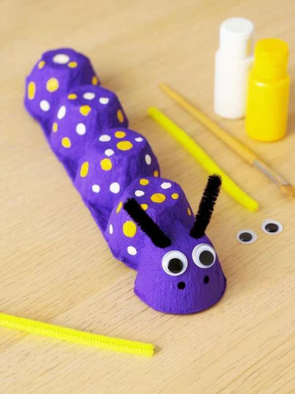 Egg-carton-caterpillar-designed-with-purple-yellow-and-white-colors.