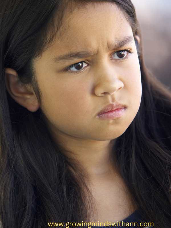 a-girl-frowning-her-face-in-how-to-parent-a-strong-willed-child-without-power-struggles.