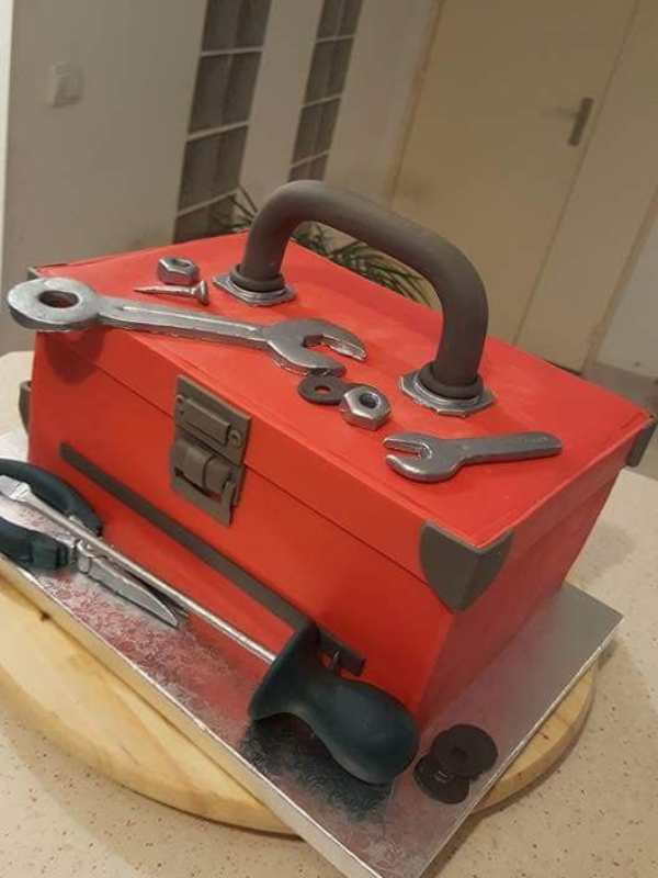 Cake-designed-as-a-red-and-black-toolbox-with-spanners-and-nots-on-it.