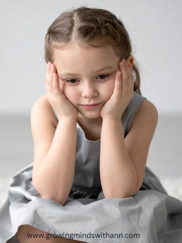 A-child-in-grey-holding-her-cheeks-with-her-2-hands.