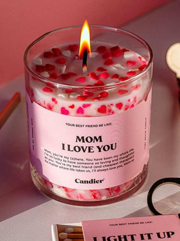 Scented-candle-in-a-glass-designed-with-pink-and-lighted-up.