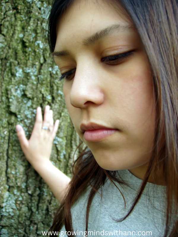 A-woman-holding-a-tree-while-lookinds-another-direction