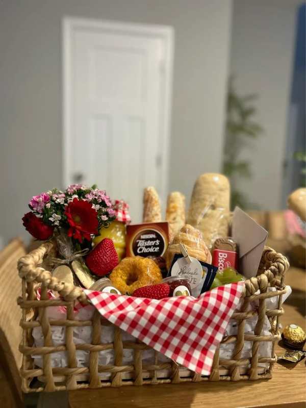 Basket-containing-doughnut-bun-apple-and-other-breafast-essentials-in-cute-teacher's-appreciation-basket-ideas.