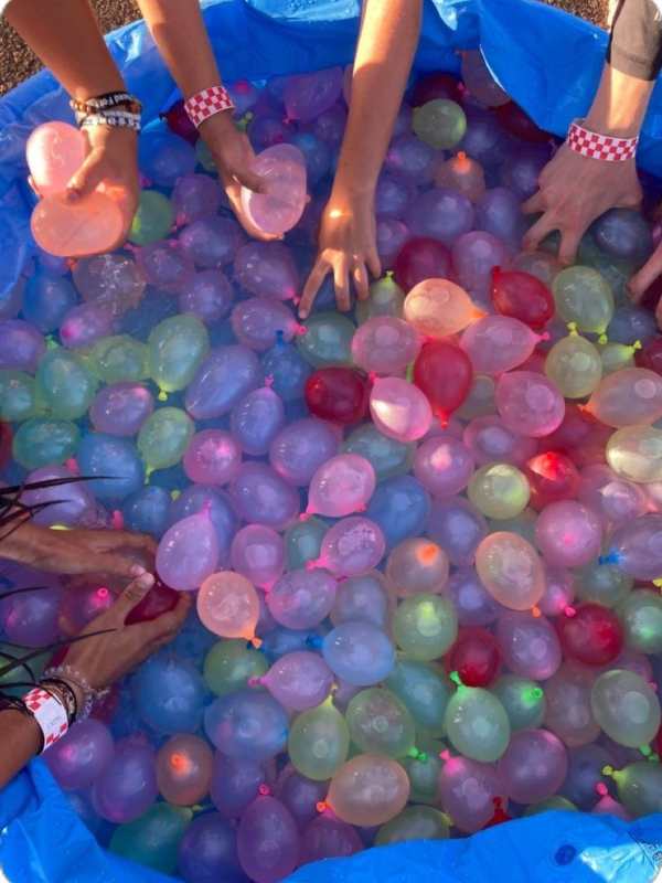 Different-colors-of-balloon-inside-bowl-of-water-3-hands-inside-the-bowl-in-fun-4th-of-july-games-your-family-will-love.