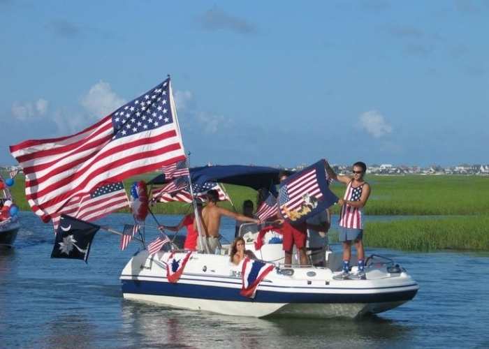 Men-and-women-in-a-boat-holding-USA-flag-in-fun-and-memorable-ways-to-celebrate-4th-of-July-without-fireworks.