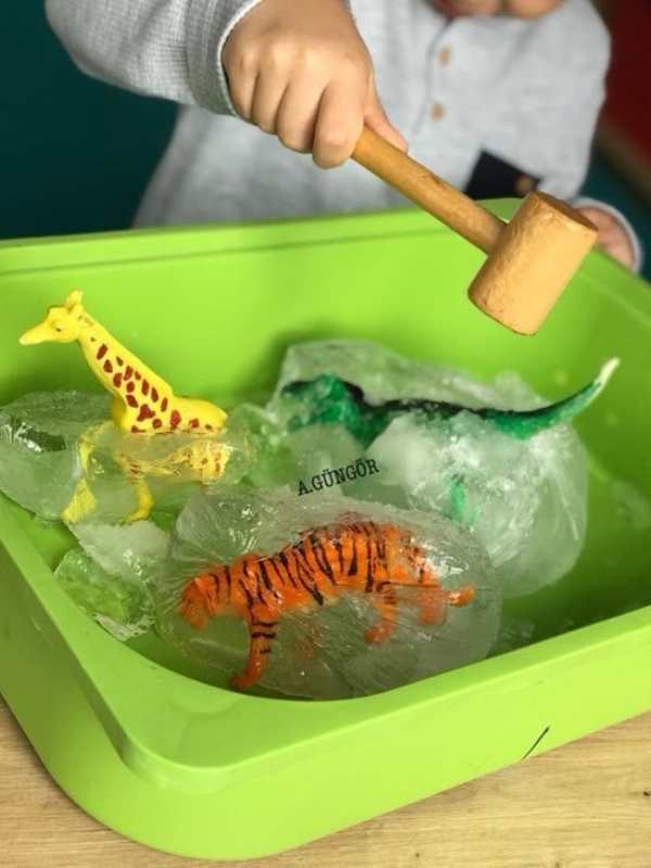Child-using-hammer-to-break-ice-to-bring-out-toys-in-easy-sensory-activities-for-toddlers-and-preschoolers.