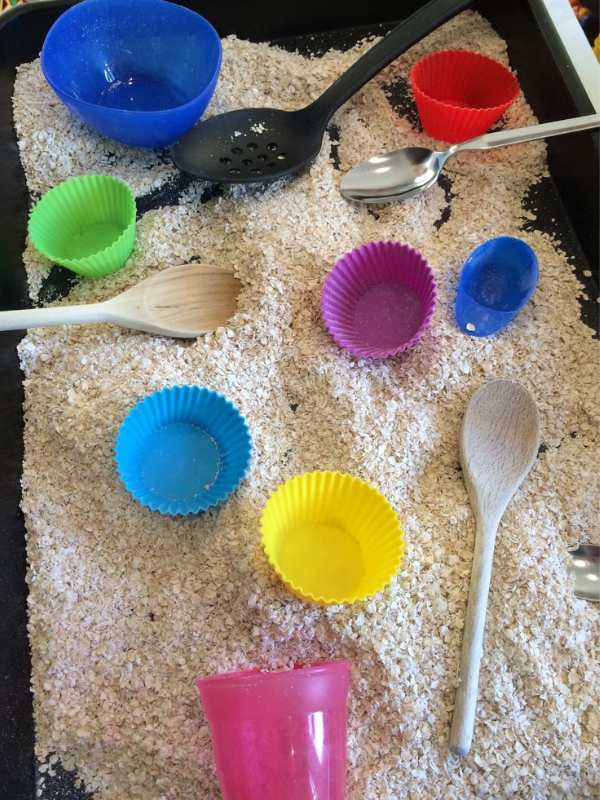 Oat-bin-with-spoons-and-scoops-in-easy-sensory-activities-for-toddlers-and-preschoolers.