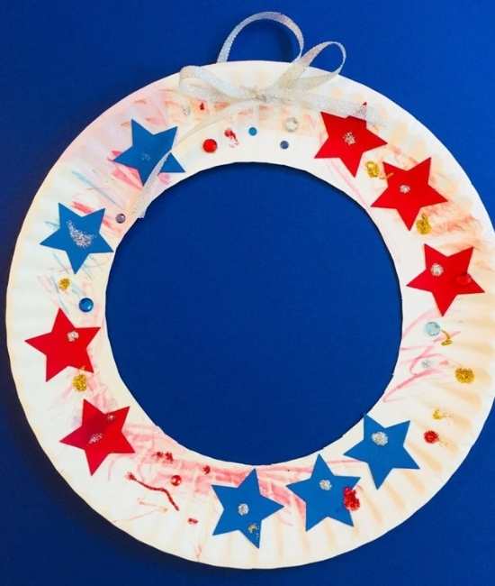 Wreath-designed-with-a-paper-plate-and-red-and-blue-stars-in-fun-and-creative-4th-of-July-crafts-for-kids.