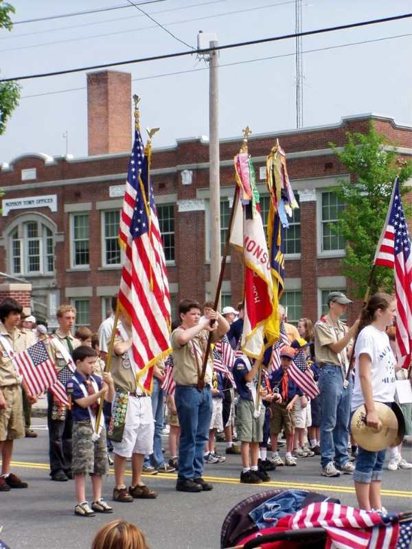 Adults-and-kids-hold-ng-flags-and-stand-ng-for-patriotic-parade.