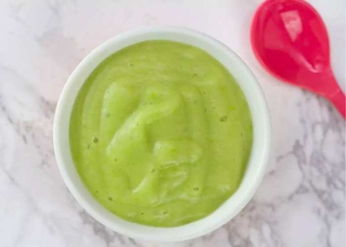White-plate-containing-pea-puree-with-a-pink-spoon-beside-it-in-healthy-homemade-baby-puree-recipes-you-can-freeze.