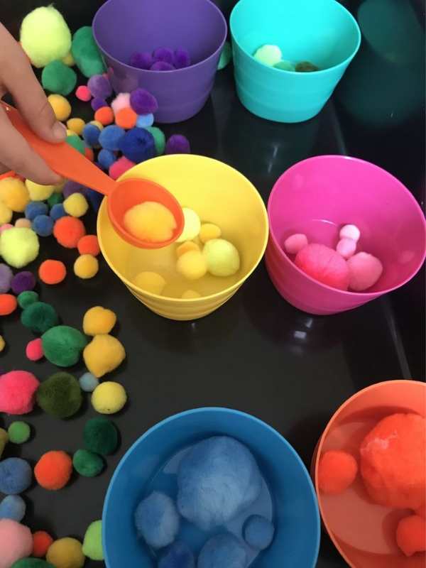 Hand-sorting-pom-pom-into-different-colors.