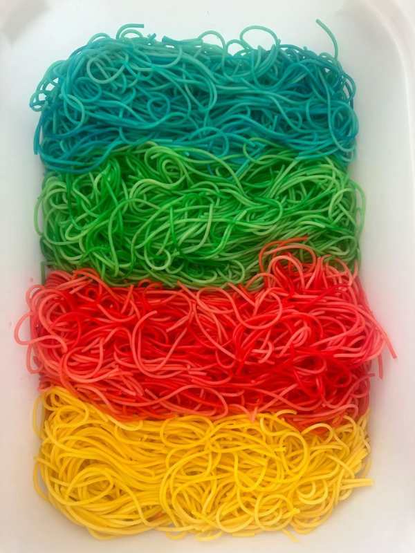 Green-blue-orange-and-yellow-dyed-spaghetti-in-easy-sensory-activities-for-toddlers-and-preschoolers.