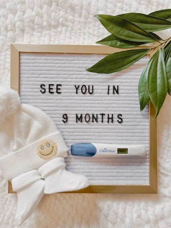 White-board-written-see-you-in-9-months-with-baBY-CAP-AND-SOCKS- beside-it-in-super-creative-pregnancy-announcement-ideas.
