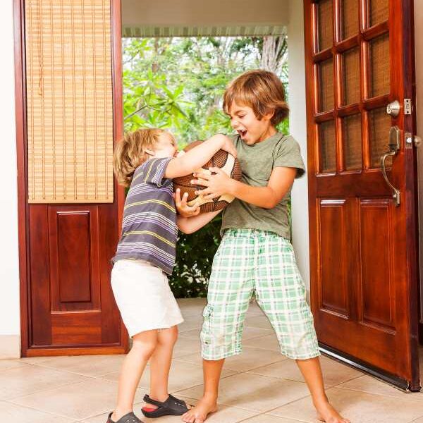 Two-kids-fighting-with-ball-in-their-hands-in-fun-sibling-bonding-activities-to-reduce-sibling-rivalry.