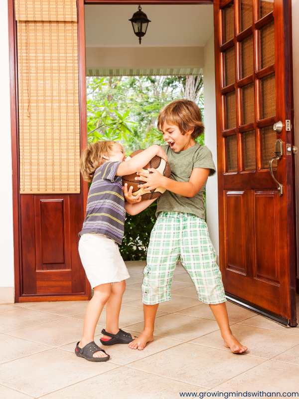 Two-kids-fighting-with-ball-in-their-hands-in-fun-sibling-bonding-activities-to-reduce-sibling-rivalry.