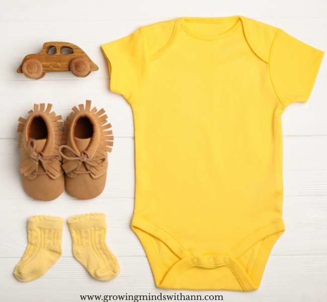 Yellow-baby-pin-down-with-baby-shoe-socks-and-car-toy-in-memorable-first-baby-announcement-ideas-to-tell-your-big-news.