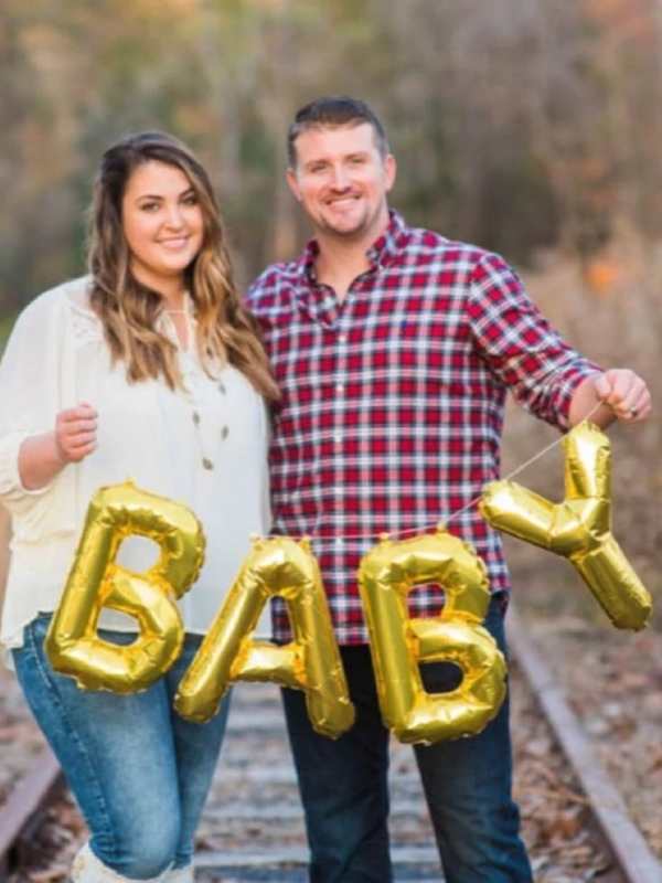 Husband-and-wife-holding-baby-balloon.