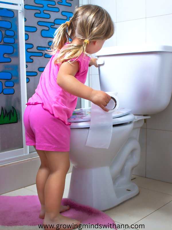 toddler-in-pink-trying-to-flush-the-toilet.