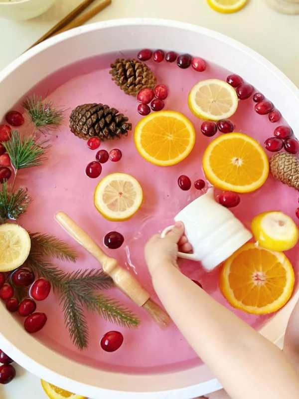 Toddler-playing-in-a-fruit-frozen-bin-in-easy-summer-sensory-activities-for-toddlers-and-preschoolers.