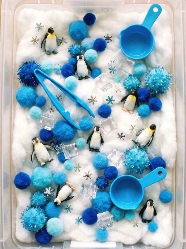 Snow-sensory-bin-with-scoops-pom-pom-and-penguin-toy-in-screen-free-snow-day-activities-for-toddlers.