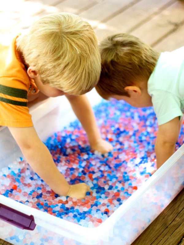 2-kids-playing-with-white-red-and-blue-sensory-bin.