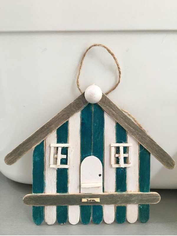 Beach-house-built-with-popsicle-sticks-and-painted-with-green-and-white.