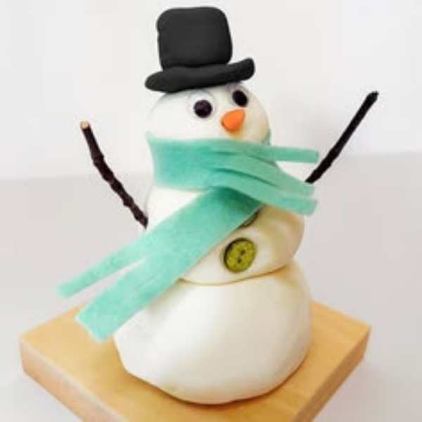Playdough-snowman-sitting-on-a-brown-tray-in-screen-free-snow-day-activities-for-toddlers.