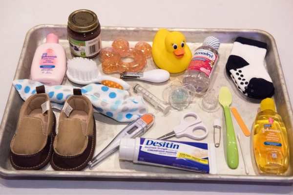 Tray-containing-baby-socks-oil-lotion-shoe-comb-and-other-essential-baby-items-in-funny-baby-shower-games.