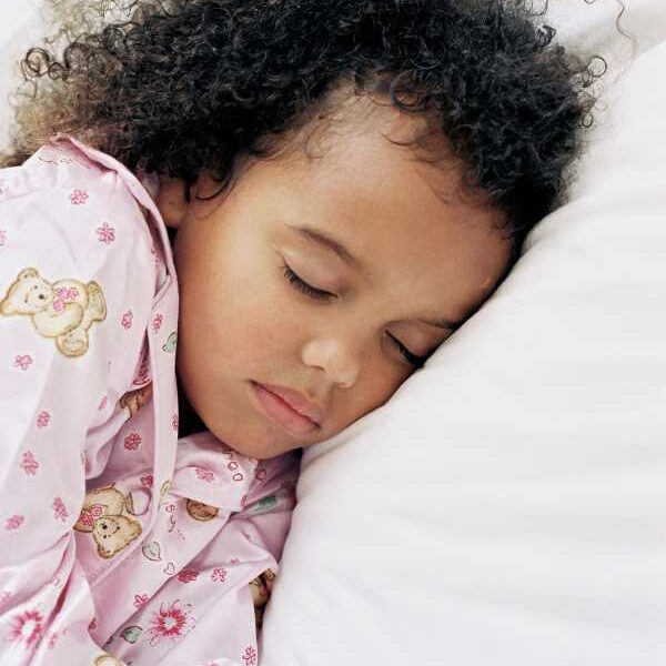 Girl-sleeping-on-a-bed-in-back-to-school-sleeping-schedule-for-kids.
