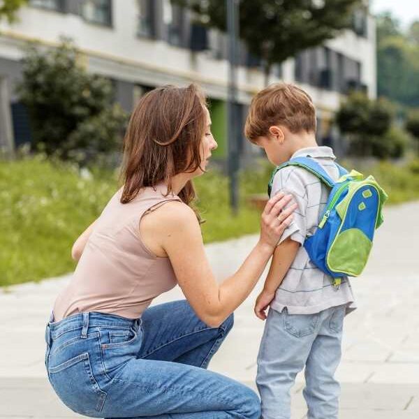 Mom-adjusting-her-child's-cloth-while-talking-to-him-in-how-to-prepare-your-child-for-their-first-day-of-school.