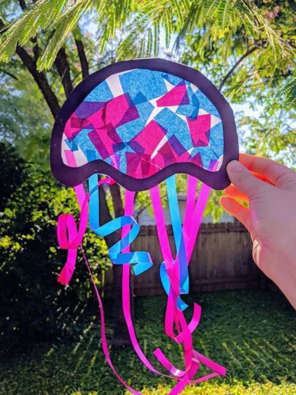 Jellyfish-sun-catcher-held-up-to-the-sun-in-sun-catcher-crafts-for-kids.