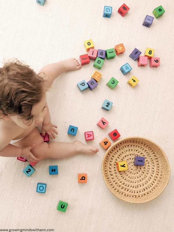 Toddler-picking-plastic-alphabet-and-putting-in-a-basket-in-low-prep-homeschool-activities-for-busy-moms.