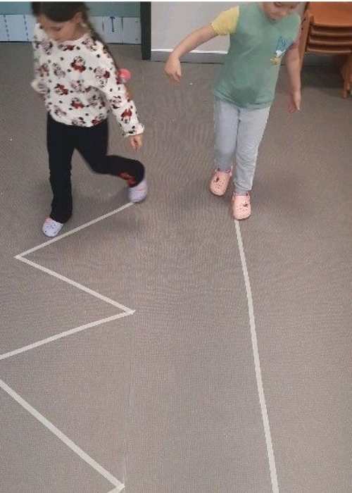Two-toddlers-walking-on-a-tape-line.