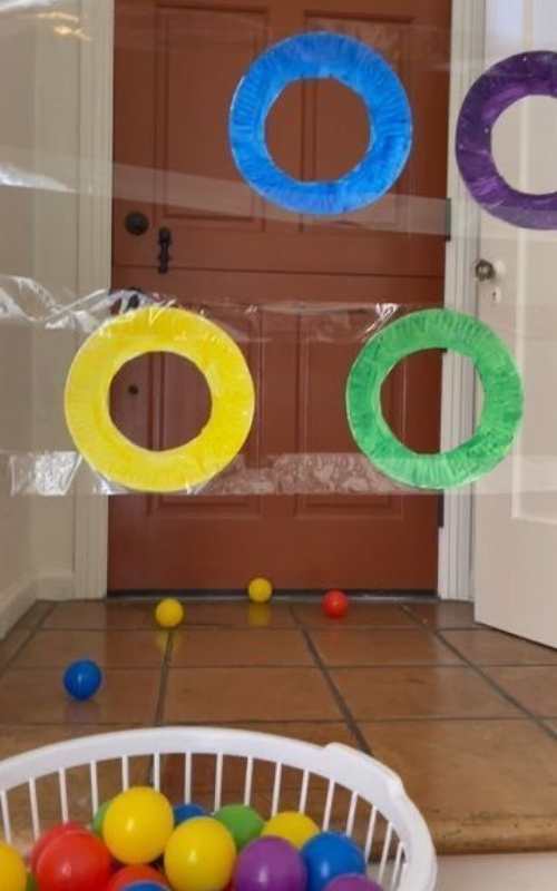 Target-toss-made-with-tape-beside-a-basket-of-light-ball-in-masking-tape-activities-for-toddlers-that-are-easy-and-fun.