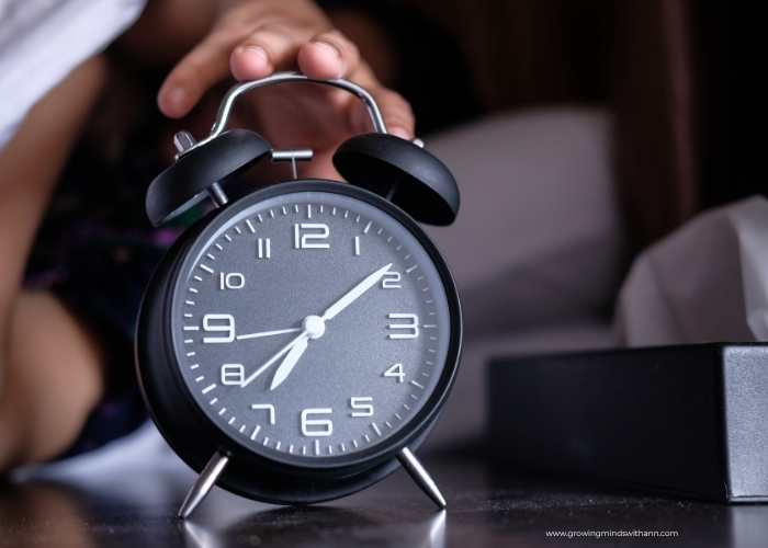 A-hand-trying-to-grab-alarm-clock-in-back-to-school-organization-hacks-for-moms.