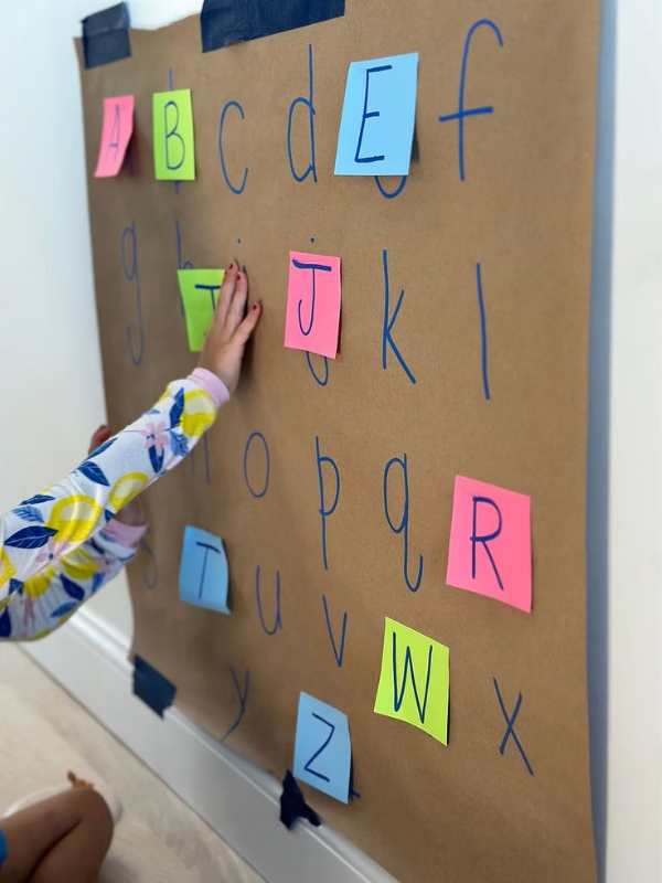 Child-matching-alphabet-on-the-board-with-the-one-on-paper-in-fun-ways-to-teach-the-alphaet-to-preschoolers.